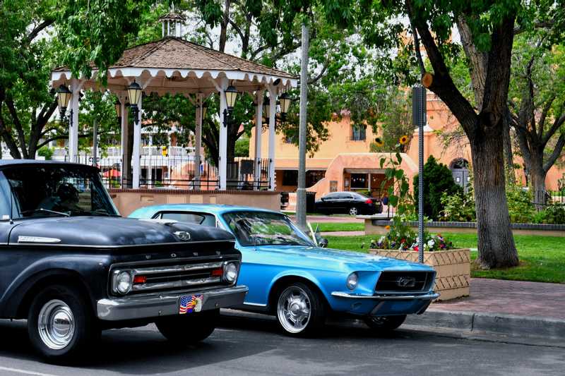 Two old Ford owners talking in front of Albuquerque Old Town park