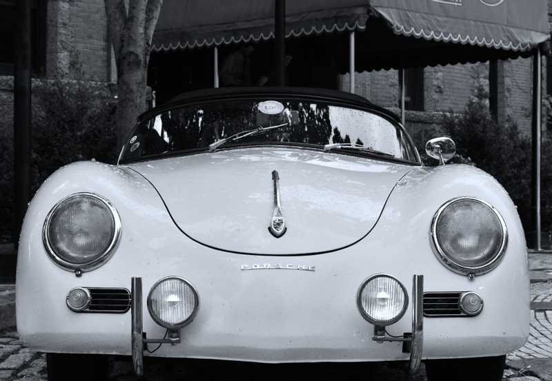 An old Porsche sits in front of a hotel