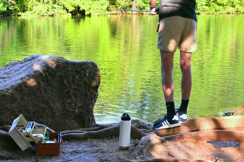 Close up on guy's fishing gear and his legs