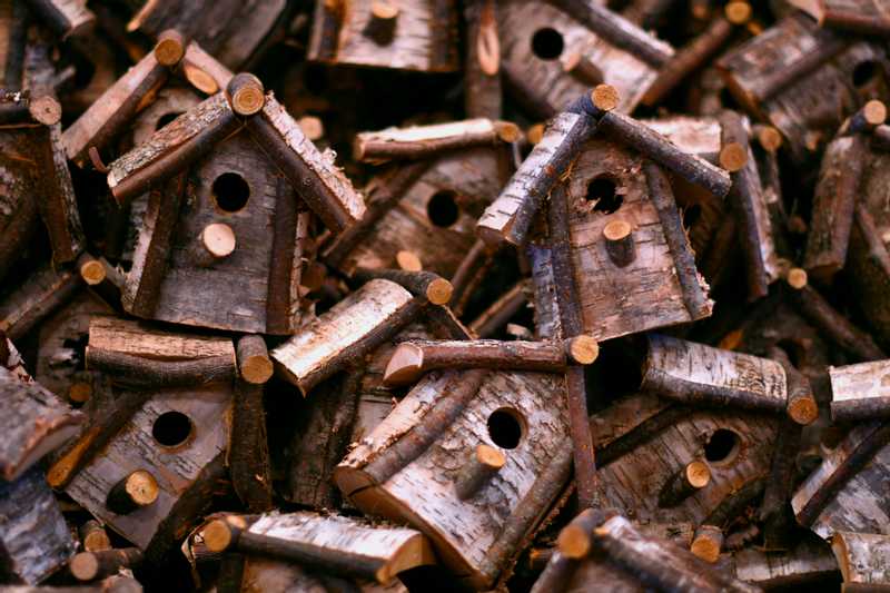 Hundreds of rustic bird houses piled onto each other.