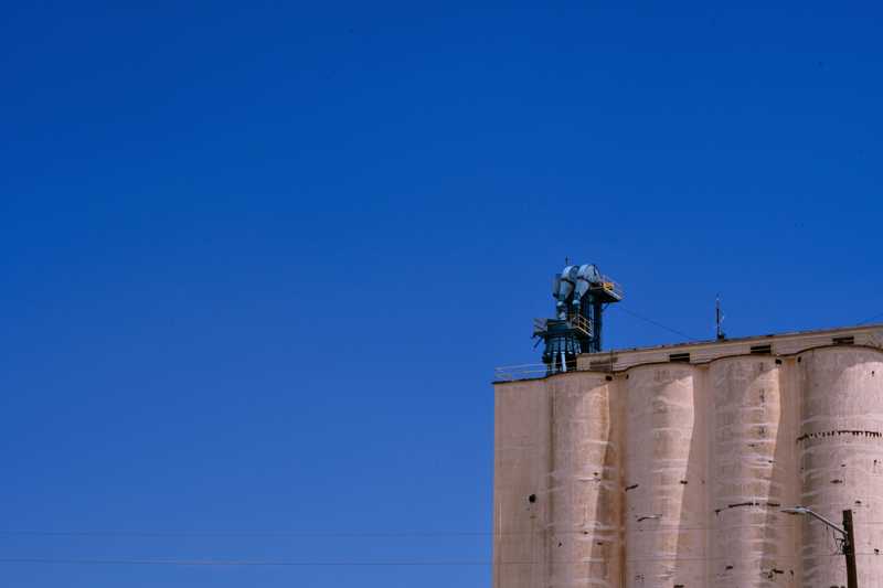 A grain mill set against a bright blue sky